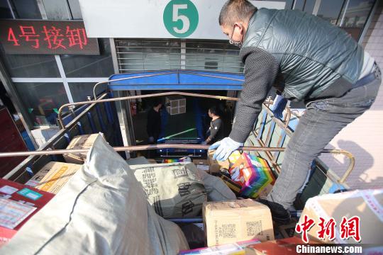 資料圖：工作人員正在給快遞包裹裝車。張?jiān)啤z